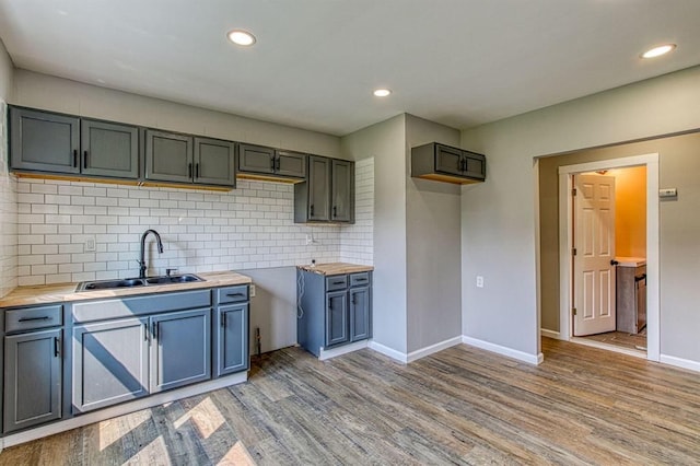 kitchen with backsplash, sink, and light hardwood / wood-style floors