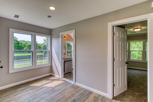 spare room with hardwood / wood-style flooring and plenty of natural light