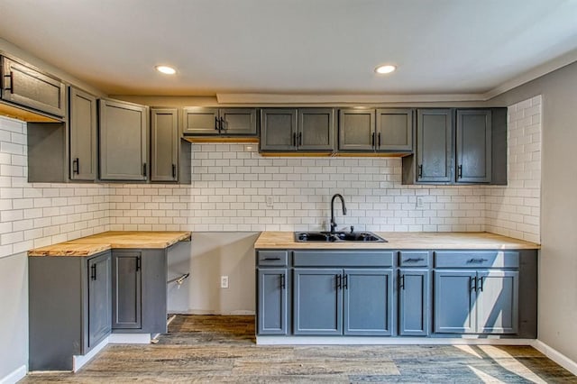 kitchen featuring backsplash, sink, wooden counters, and wood-type flooring