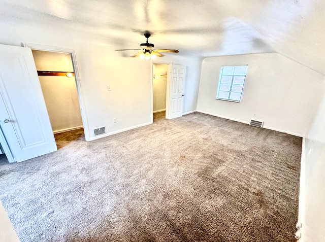 unfurnished bedroom featuring a textured ceiling, ceiling fan, carpet, and lofted ceiling