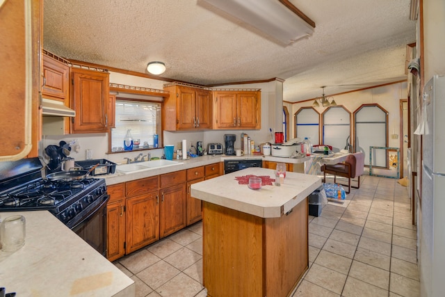 kitchen featuring ornamental molding, a textured ceiling, black appliances, sink, and a kitchen island