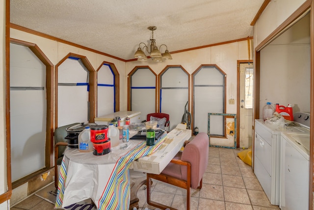 dining area featuring washing machine and clothes dryer, ornamental molding, a textured ceiling, and an inviting chandelier