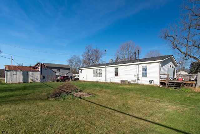 rear view of house featuring a yard