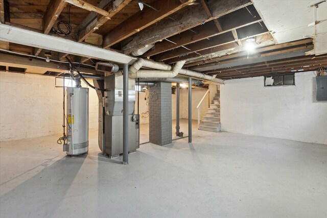 basement featuring electric panel, heating unit, and water heater