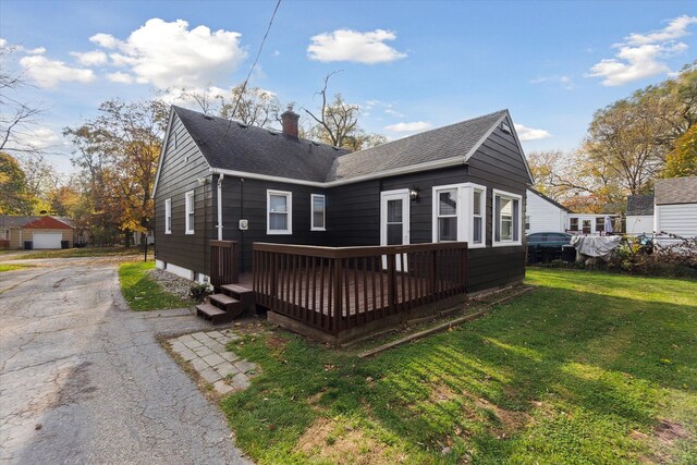 back of property featuring a yard and a wooden deck