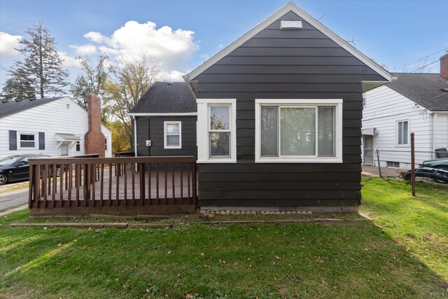 back of property featuring a lawn and a deck