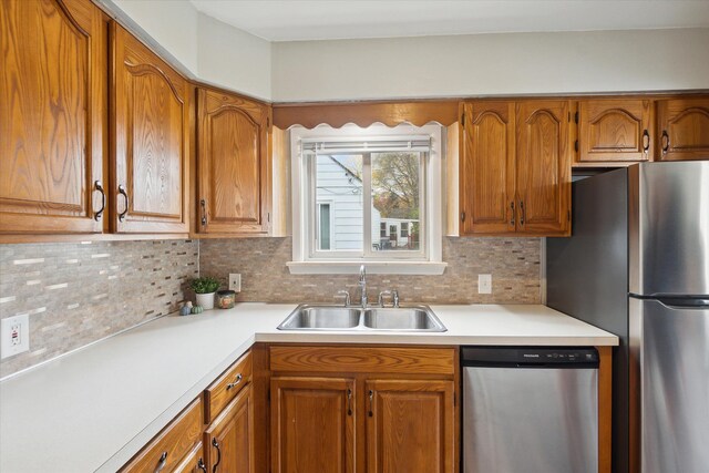 kitchen with appliances with stainless steel finishes, tasteful backsplash, and sink