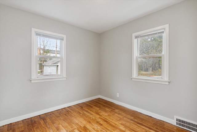 unfurnished room with plenty of natural light and light hardwood / wood-style floors