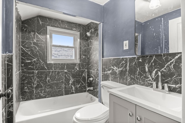 full bathroom featuring vanity, tiled shower / bath combo, toilet, and tile walls