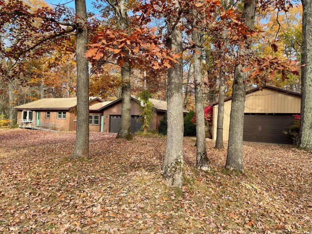 7468 W 6 1/2 Mile Rd, Irons, MI 49644 - view of front facade featuring a garage and an outbuilding