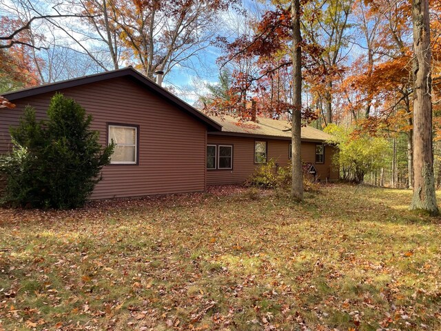 7468 W 6 1/2 Mile Rd, Irons, MI 49644 - view of property exterior featuring a lawn