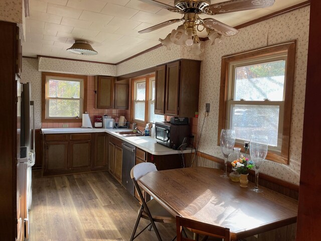 7468 W 6 1/2 Mile Rd, Irons, MI 49644 - kitchen with wallpapered walls, stainless steel dishwasher, ornamental molding, light wood-style flooring, and plenty of natural light