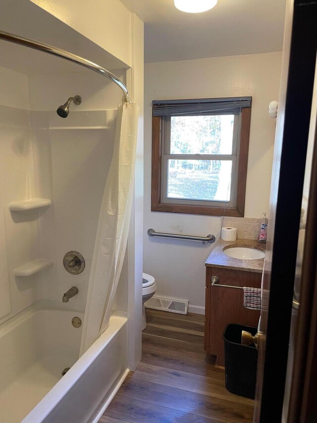 7468 W 6 1/2 Mile Rd, Irons, MI 49644 - full bath featuring wood finished floors, toilet, vanity, shower / tub combo, and baseboards