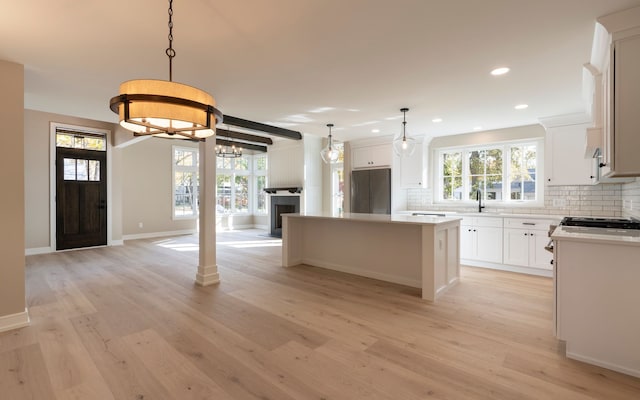 kitchen with backsplash, stainless steel fridge, light wood finished floors, and a kitchen island