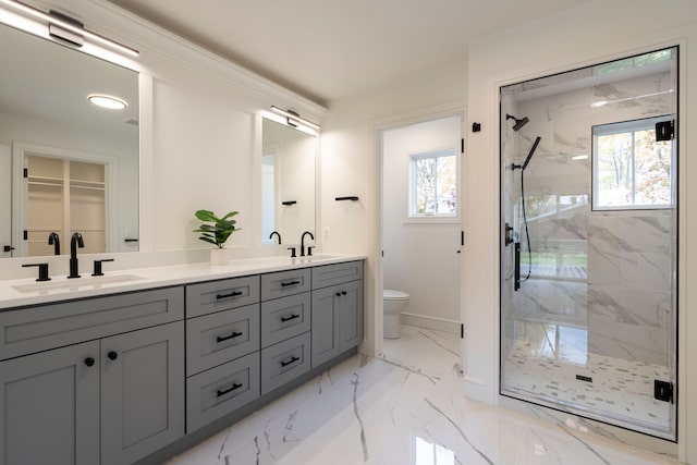 bathroom featuring a marble finish shower, toilet, double vanity, marble finish floor, and a sink