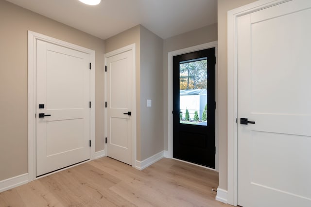 foyer entrance featuring light wood-type flooring and baseboards