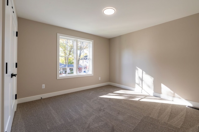 carpeted empty room with visible vents and baseboards