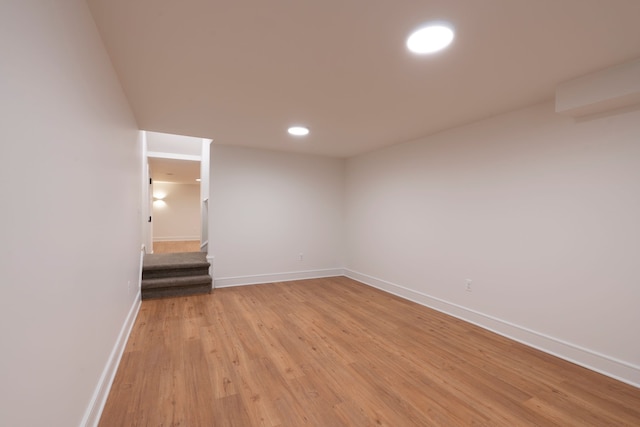 empty room featuring recessed lighting, stairway, baseboards, and light wood-style flooring