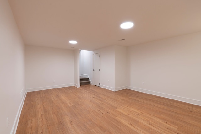 empty room with stairway, light wood-style flooring, recessed lighting, and baseboards