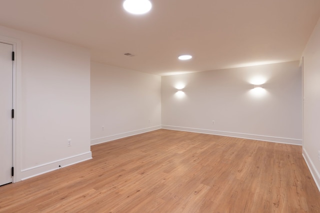 empty room with light wood-type flooring, baseboards, and visible vents