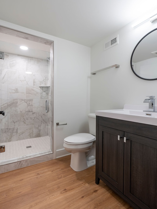 full bath featuring visible vents, toilet, a stall shower, wood finished floors, and vanity