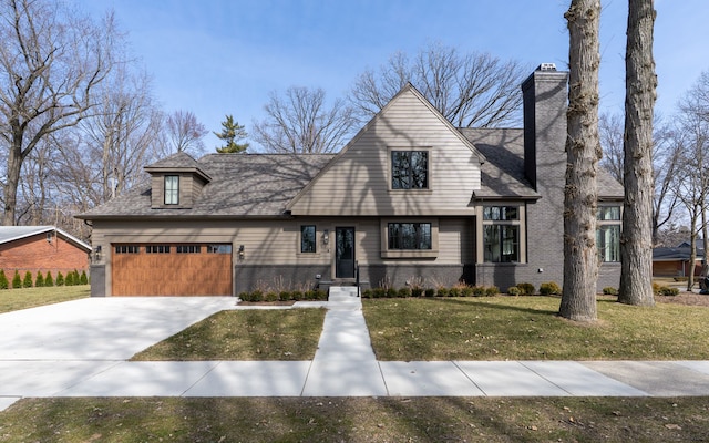 view of front of property with an attached garage, a shingled roof, a chimney, a front lawn, and concrete driveway