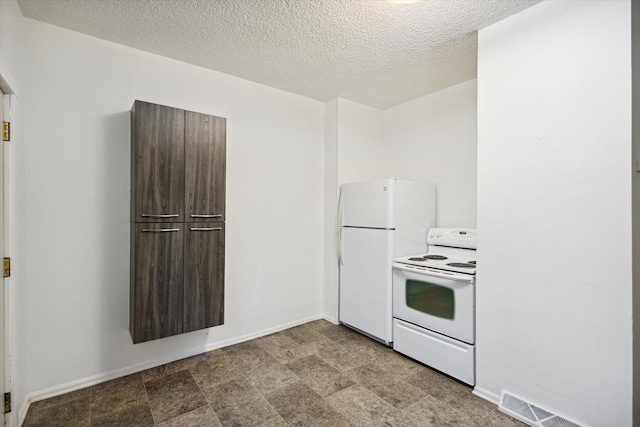 kitchen with dark brown cabinets, white appliances, and a textured ceiling