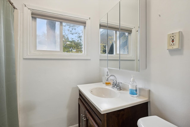 bathroom with vanity, a healthy amount of sunlight, and toilet