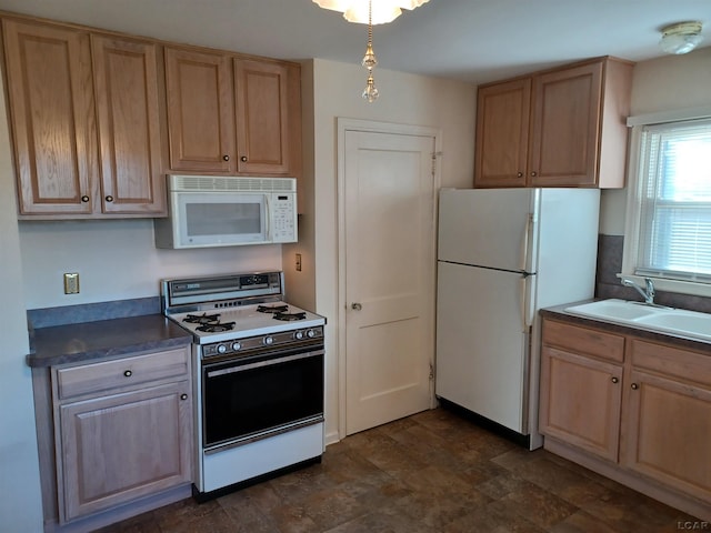 kitchen with light brown cabinets, white appliances, and sink