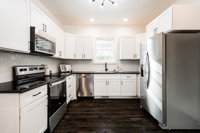 kitchen with dark wood-type flooring, sink, white cabinetry, and stainless steel appliances