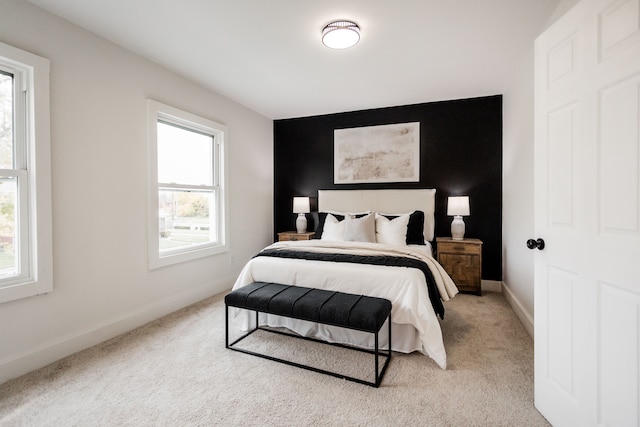 bedroom featuring light carpet and multiple windows