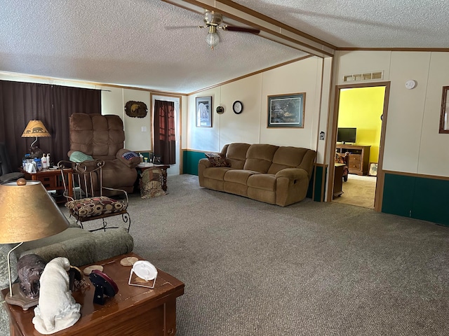 carpeted living room with a textured ceiling, vaulted ceiling, ceiling fan, and ornamental molding