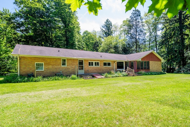 back of property with a yard and central air condition unit