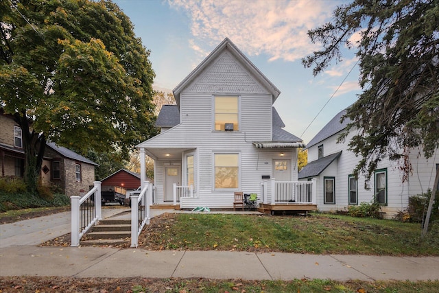 view of front of house featuring a garage, an outdoor structure, and a lawn