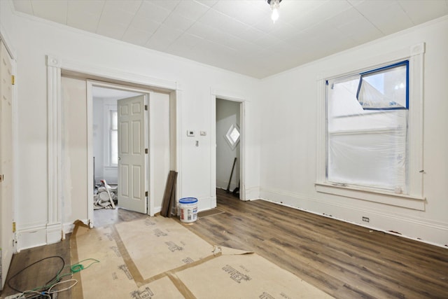 spare room with crown molding and wood-type flooring