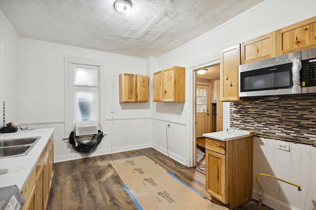 kitchen with sink, crown molding, decorative backsplash, a textured ceiling, and dark hardwood / wood-style flooring