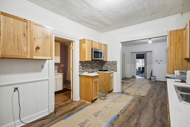 kitchen with crown molding, dark wood-type flooring, and a textured ceiling