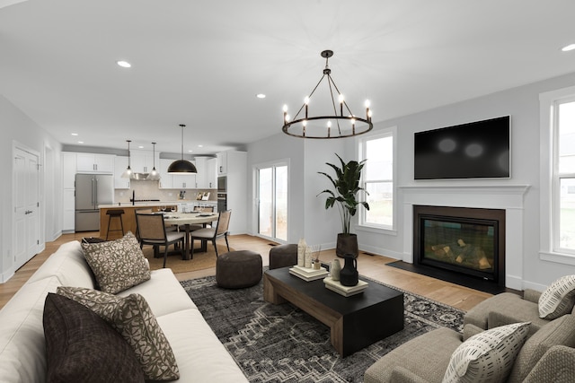 living room featuring light wood-type flooring and an inviting chandelier