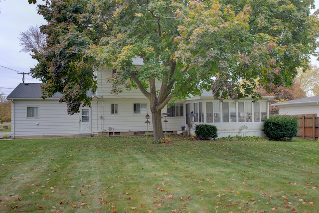 back of house with a yard and a sunroom