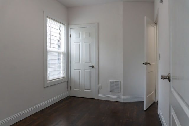 unfurnished bedroom featuring dark hardwood / wood-style flooring