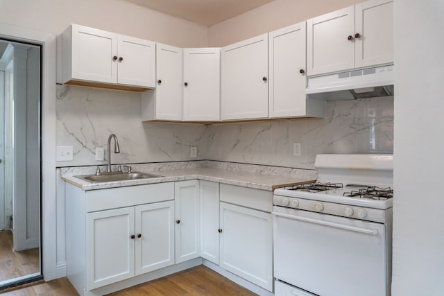 kitchen with white cabinets, light hardwood / wood-style floors, sink, and white gas range oven