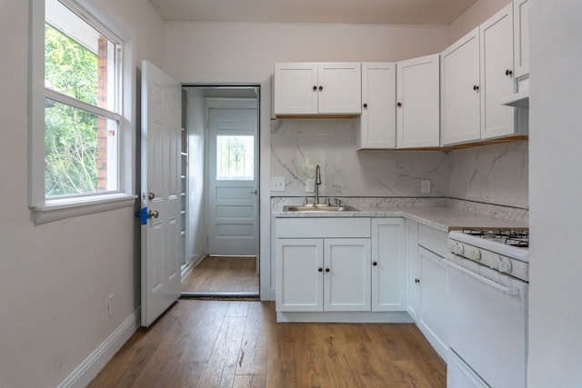 kitchen with white cabinets, white gas stove, and sink