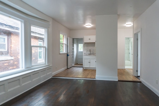 kitchen featuring tasteful backsplash, dark hardwood / wood-style flooring, white cabinets, and sink