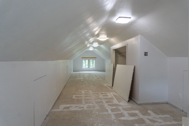 bonus room featuring light colored carpet and vaulted ceiling