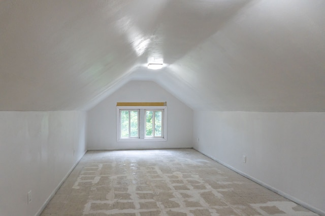 additional living space with light colored carpet and lofted ceiling