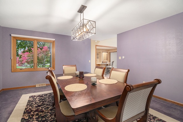 dining room with concrete floors and an inviting chandelier