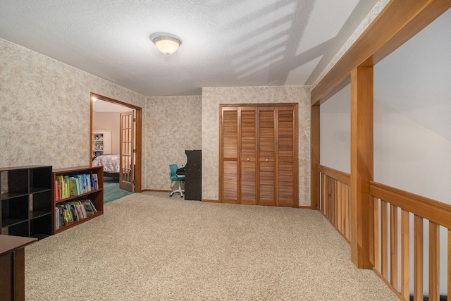 interior space featuring carpet and a textured ceiling