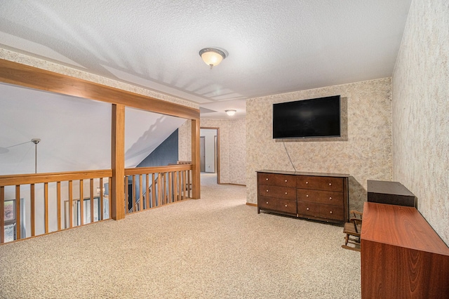 interior space featuring a textured ceiling, carpet floors, and lofted ceiling