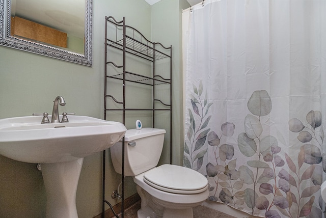 bathroom with a shower with shower curtain, toilet, and sink