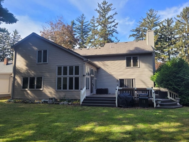 back of property with a wooden deck, a yard, and central AC